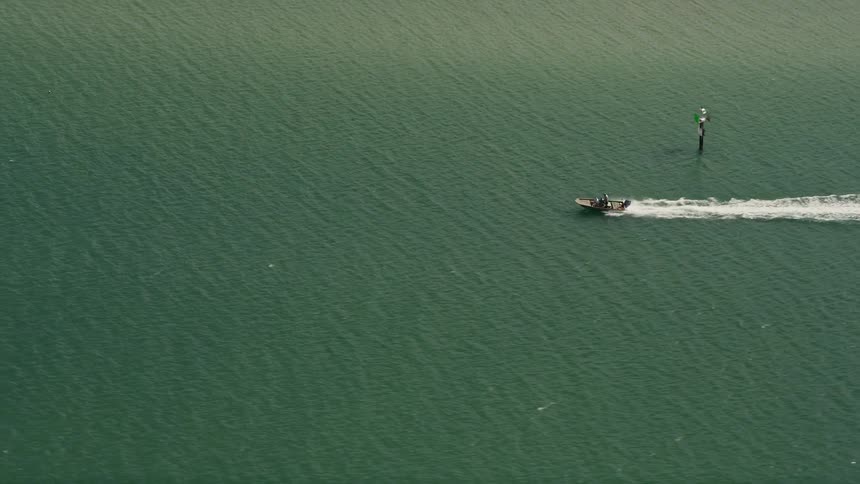 A speedboat cruises across the Indian River in Stuart Florida captured in stunning 5K aerial footage during the summer providing a perfect recreation for water sports enthusiasts