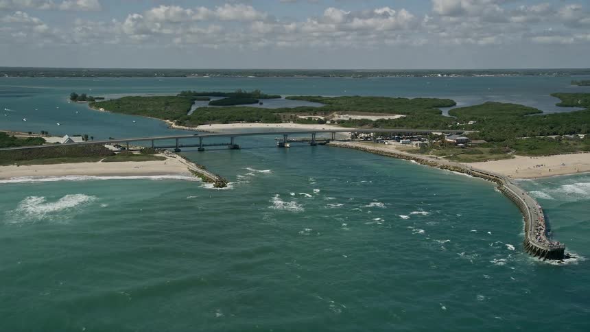 Flying over the Sebastian Inlet bridge in Vero Beach Florida capturing crystal blue waters and the stunning coastline on a partly cloudy day