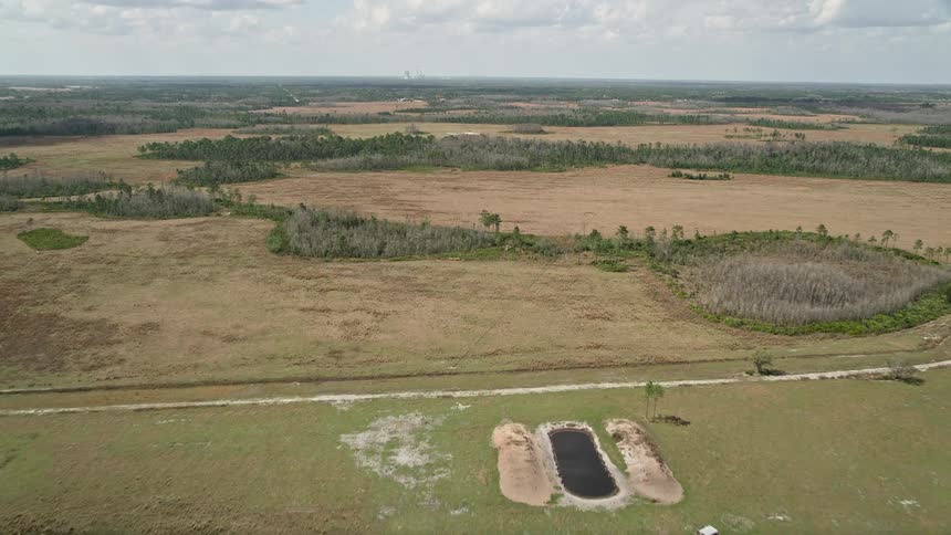 A breathtaking aerial view flying above the marshland in Wedgefield Florida featuring wetlands sloughs and sparse patches of trees on the fields during the daytime in spring or summer