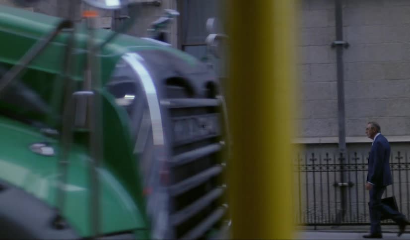 Older man walking down city sidewalk daytime garbage truck wipes screen