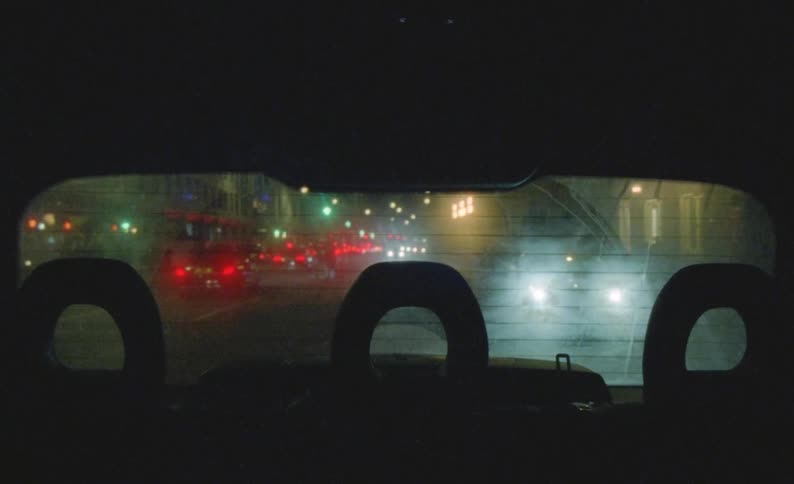 View from the back of a car driving on the city at night