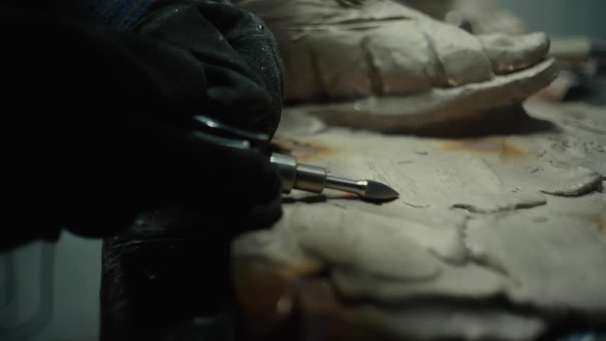 A man creates a mold for a shoe