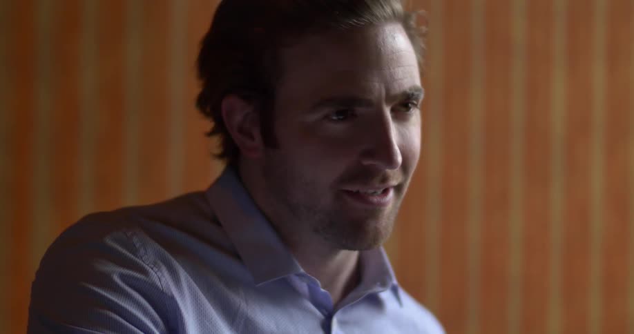 A man looking at something, smiling and talking