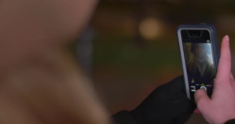 A person is using a phone to talk with someone on camera
