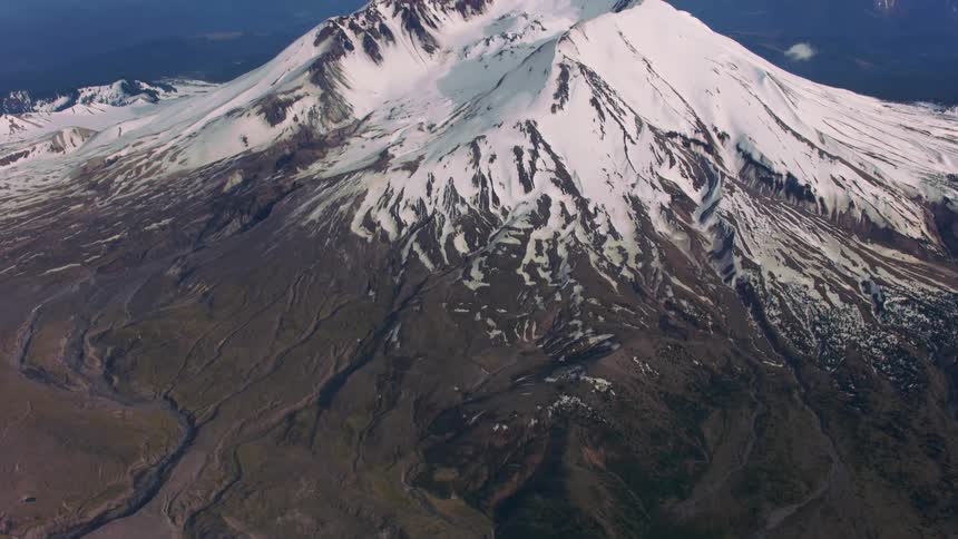 Aerial view of the snow covered peak of a mountain at evening