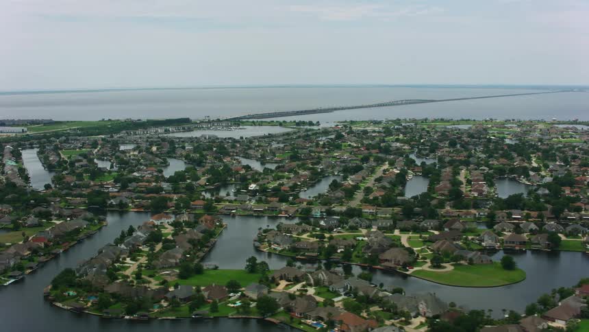 A wide view of a big city surrounded by water with green plants and buildings dominating the landscape