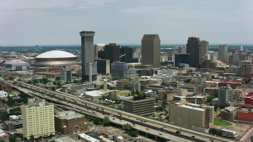 A large freeway full of cars runs along side of a major city