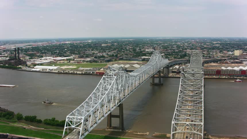 Drone view of a bridge going over a waterway connecting a city and a suburban neighborhood