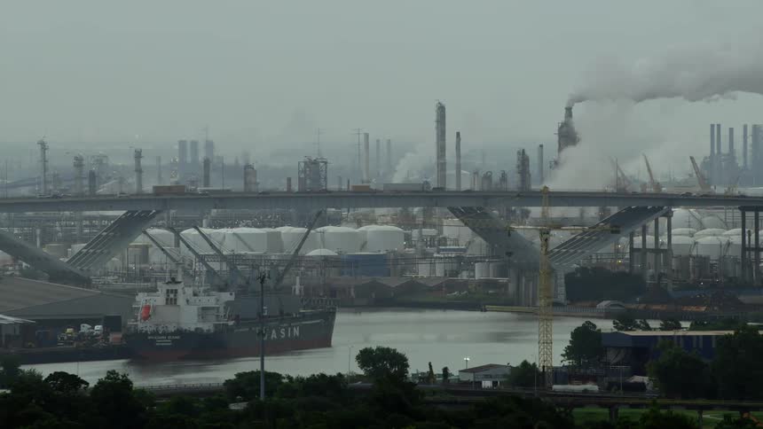Smog from a factory fills the air along a bridge