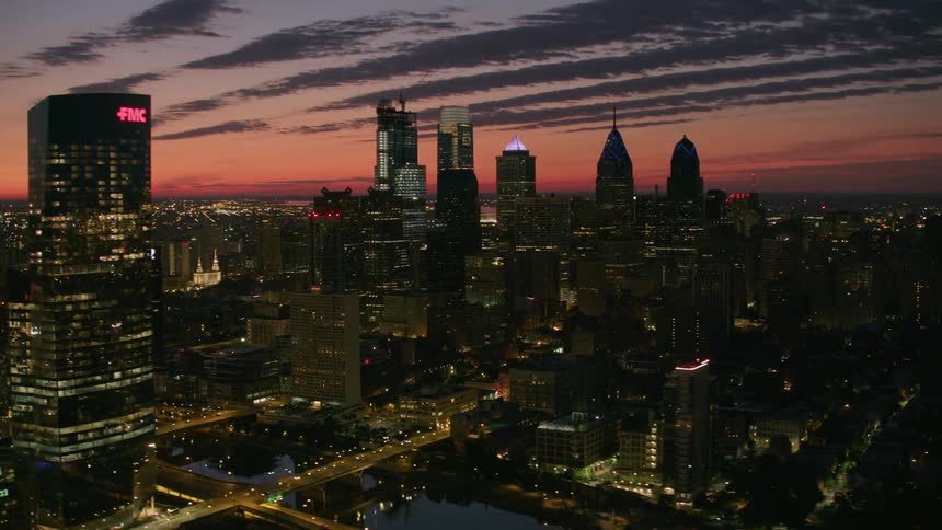 Aerial view of illuminated skyscrapers at sunset in the city