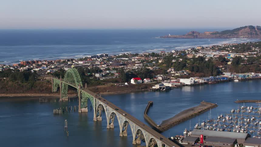 Arched bridge crosses harbor near marina connecting sides of town