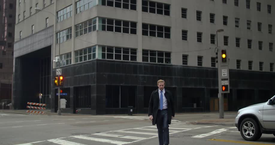 A man in a suit crosses the street