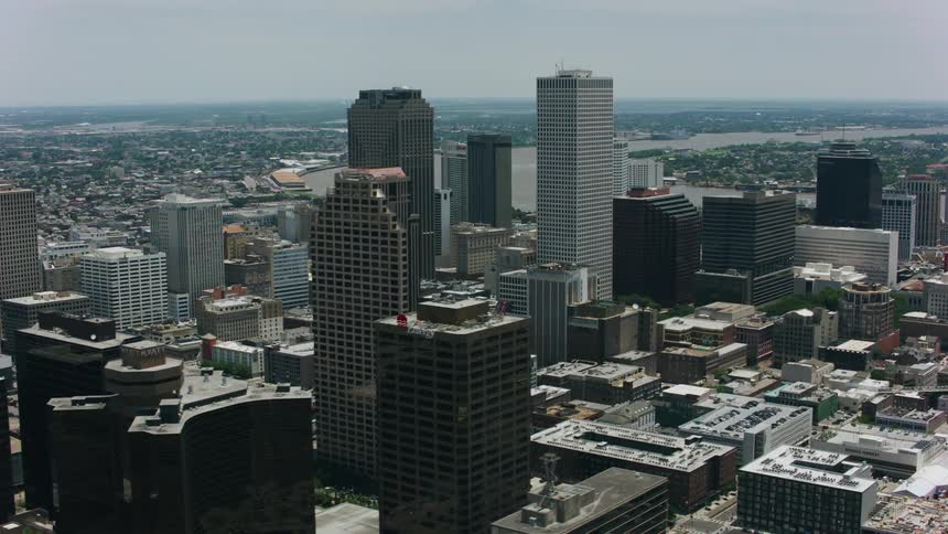An aerial of a city skyline in mid day with tall skyscrapers and a river in the background