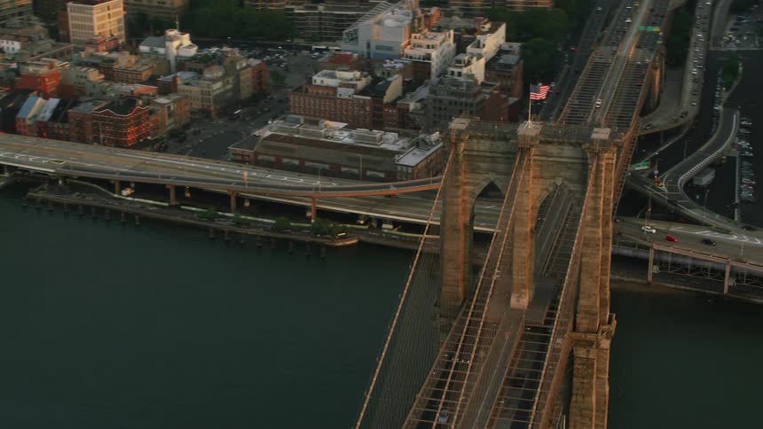 Aerial view of the american flag waving over the brooklyn bridge in new york city at evening