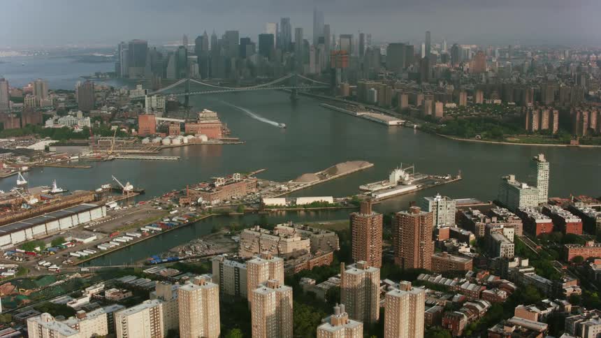 An aerial view of a river and harbor downtown near a metropolitan bridge