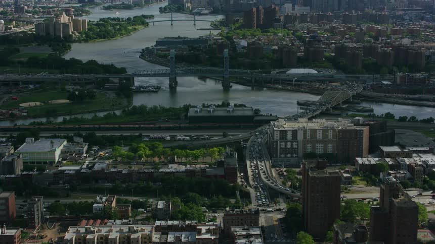 An aerial of a metropolis and suburban neighborhood with a river running through it and bridges connecting the neighborhoods