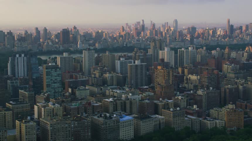An aerial view of a dense metropolis around a lake with lots of big skyscrapers