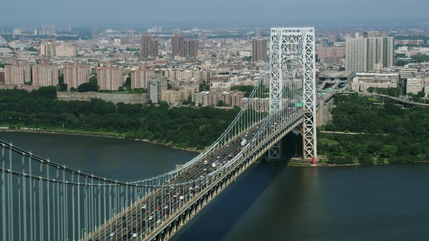 Aerial view of a suspension bridge over a river next to the city at daytime