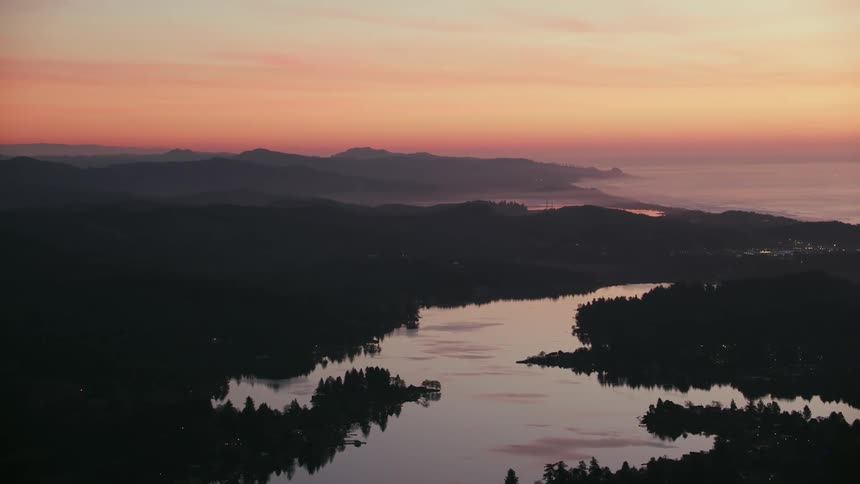 Aerial view of a river near the coast next to the ocean at evening