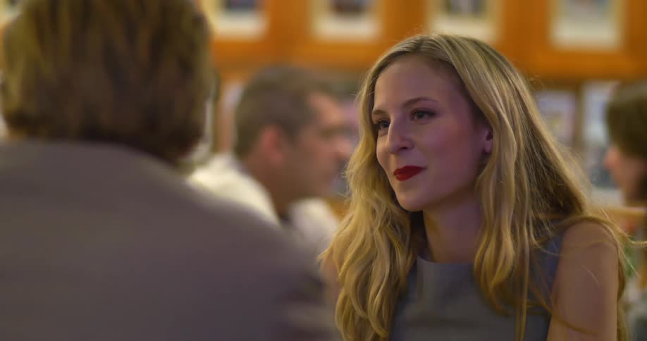 A man and a woman sitting in a restaurant and talking