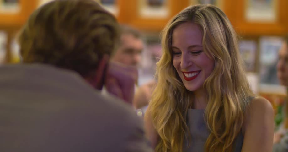 A man and a woman chatting and laughing at a table in a restaurant
