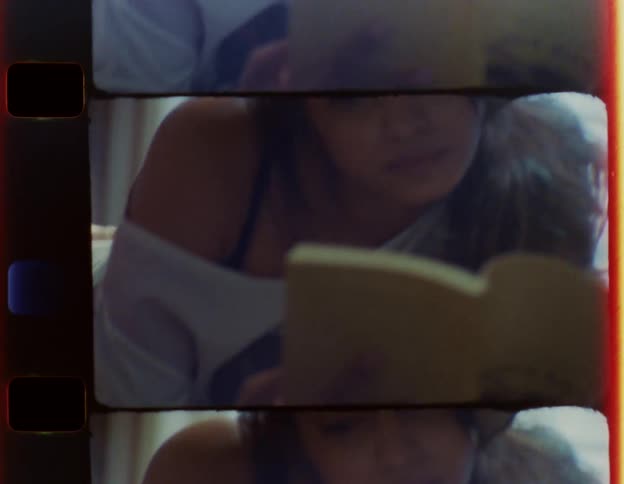 A woman reads while lying in bed