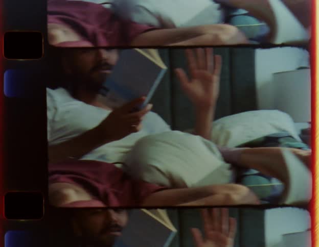 A man and woman read books in bed