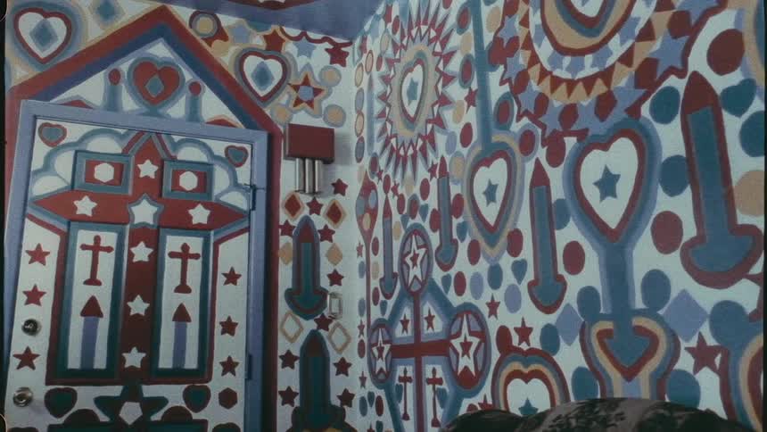 The interior of a room completely wall papered with blue abstract designs