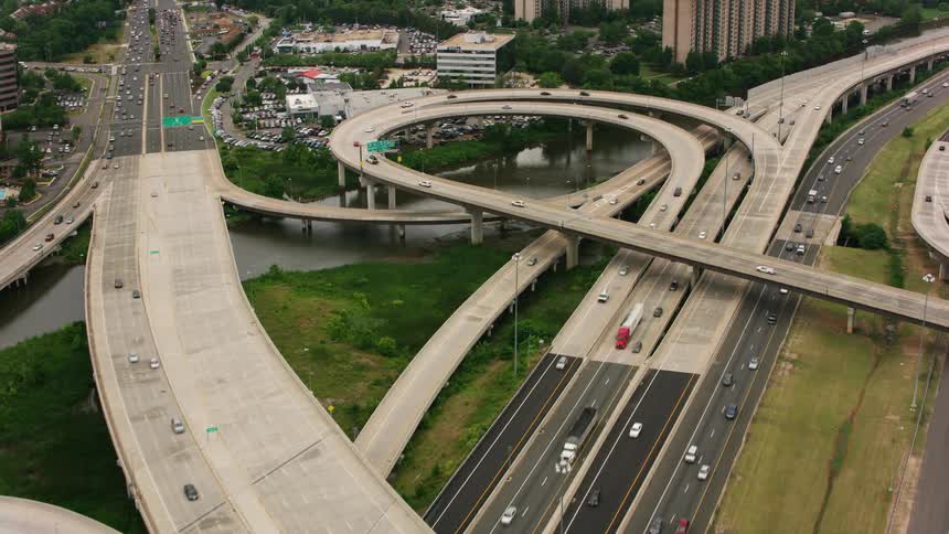 Vehicles drive down a connected freeway system through downtown