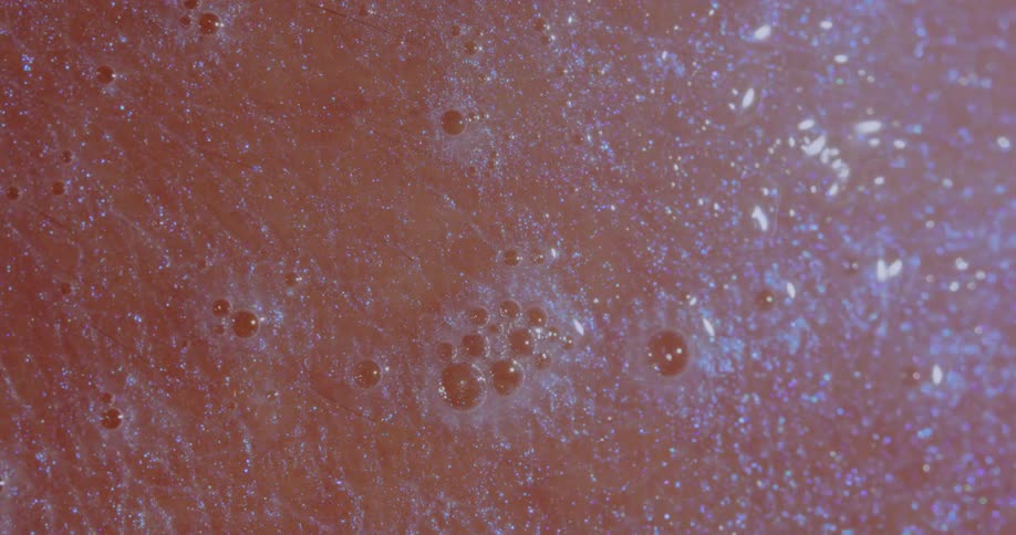 A bubbly soapy liquid being absorbed by human skin