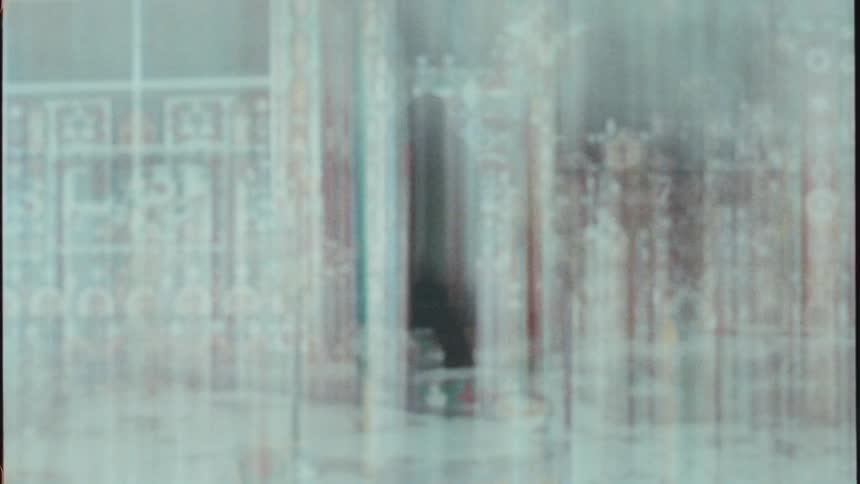 Silhouette moves on opposite side of streaky patterned window