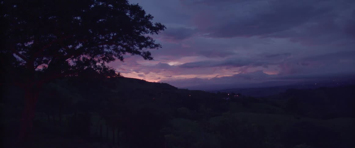 Clouds hovering above a hilly countryside during sunset