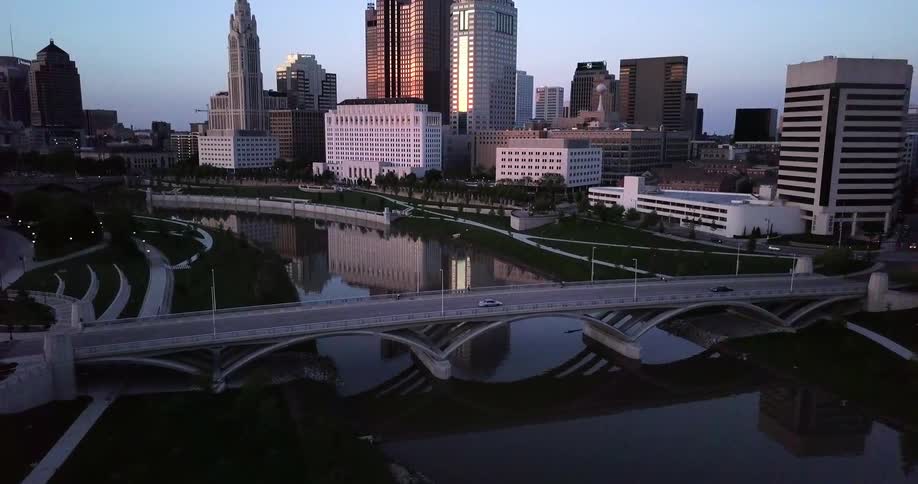 Cars drive along a bridge towards a city