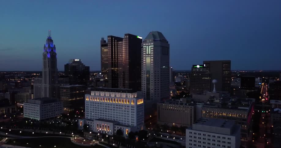 The city has many tall brightly lit cities at dawn