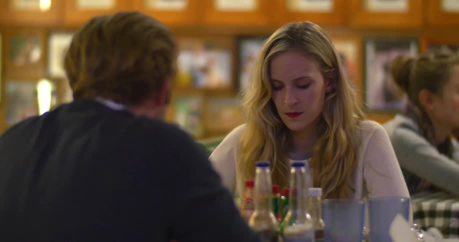 A woman looks angry as she sits in a restaurant with a man