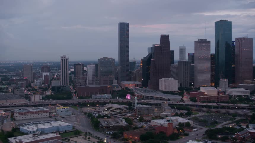 Heavy traffic passes down a highway past the city skyline