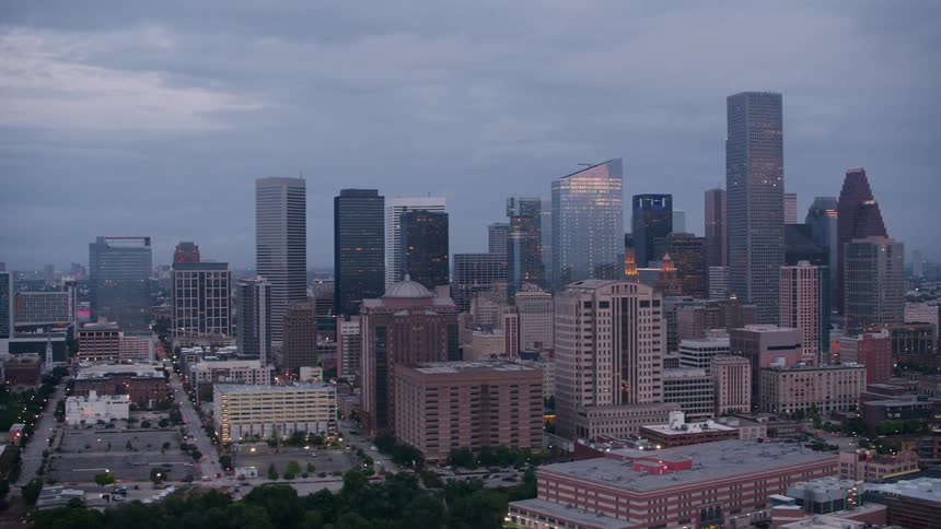 An aerial view of high rise office buildings and cars driving in a city