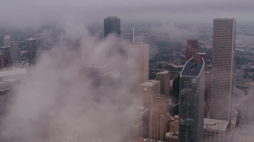 Towers and skyscrapers stand tall overlooking the city high among the clouds in the sky