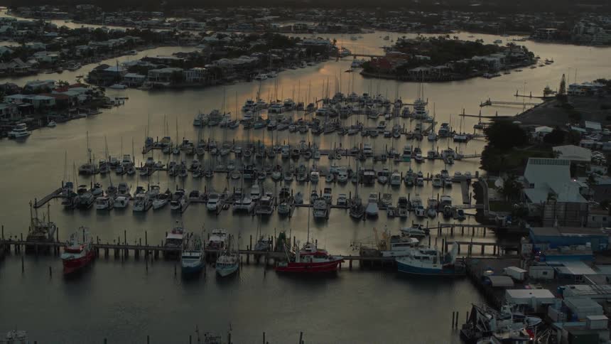 An aerial view of a harbor town with many rows of docks and fishing boats