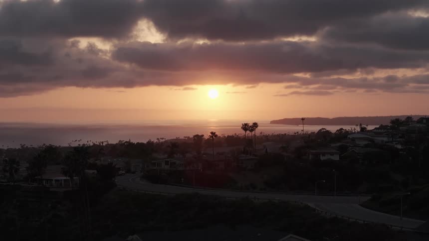 The sun low in the sky over a small summer town