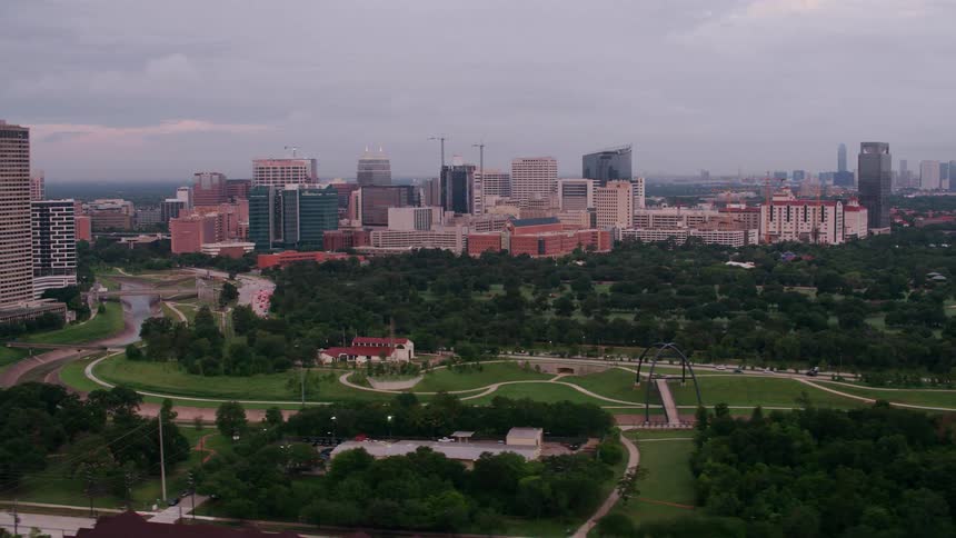 River winds through parkbetween highrise buildings a distance form the city downtown