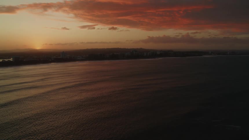 The sun sets behind the ocean