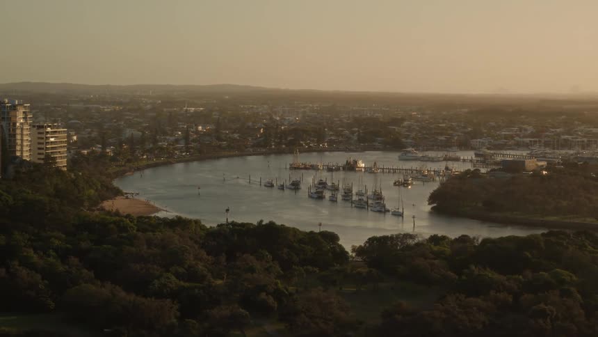An aerial view of boats on a water by a neighborhood