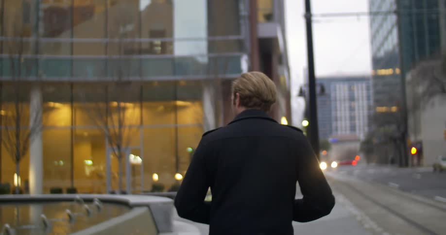 A man walks down the road in a city