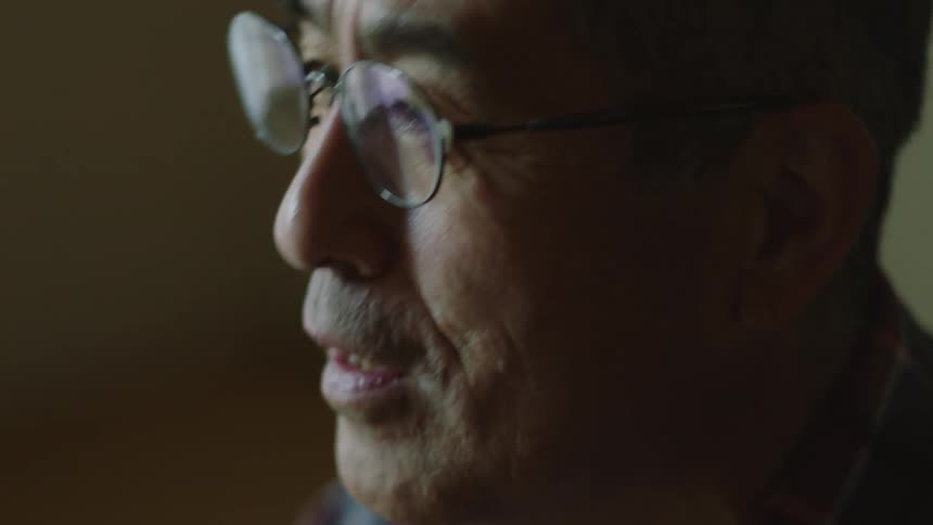 A man speaks to someone indoors