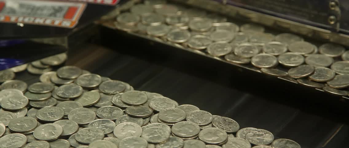 Machine pushes silver coins on a tray