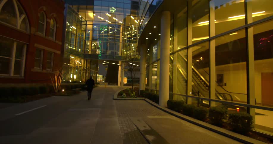 A man walking between two buildings at night