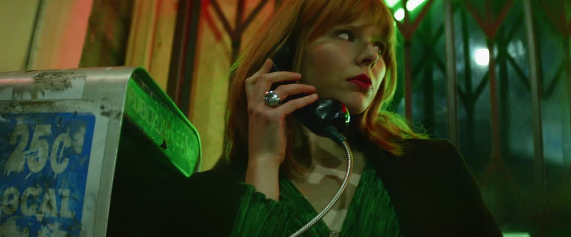 A woman is talking on the pay phone