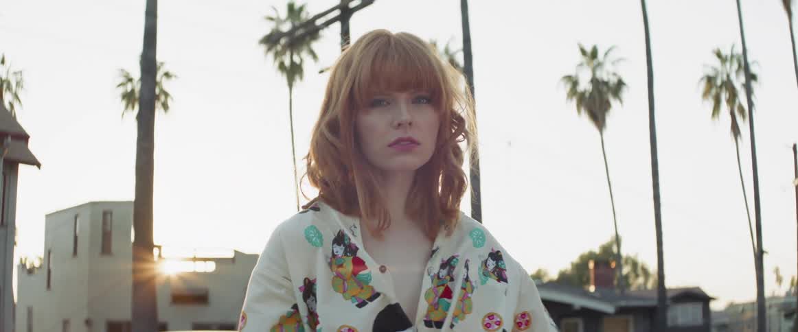 A woman poses outside at sunset