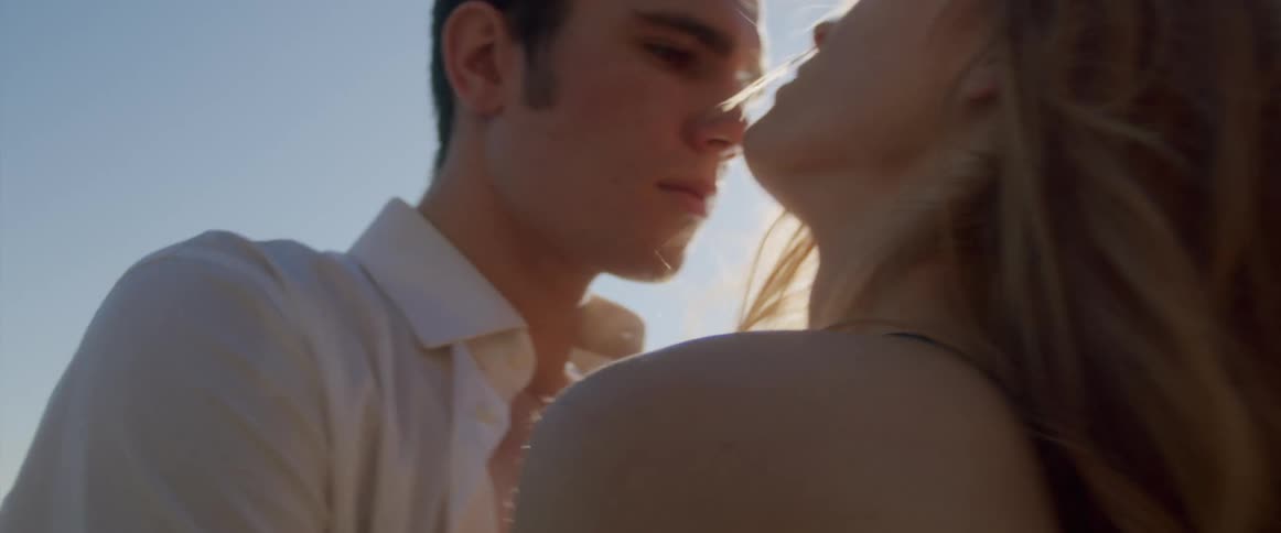 A man and woman hugging and looking in to one anothers eyes outside